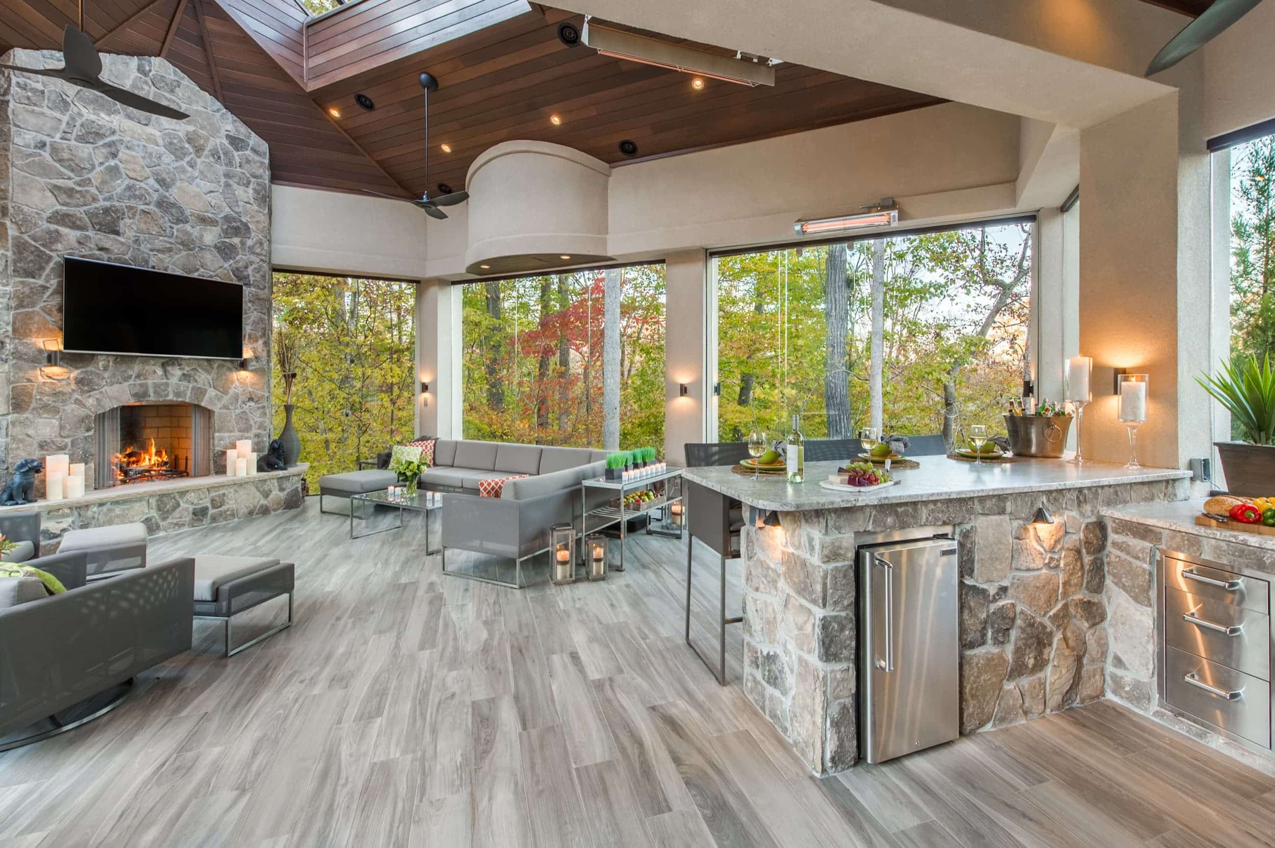 An outdoor kitchen with stone walls and a fireplace.