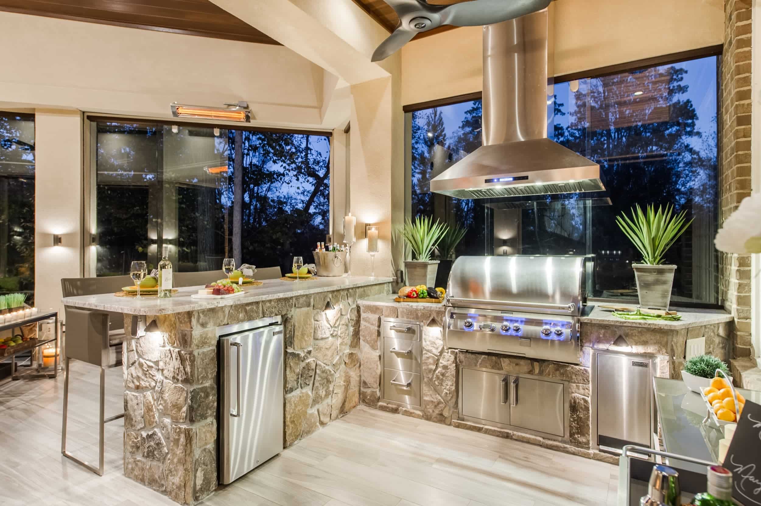 An outdoor kitchen with a grill and sink.