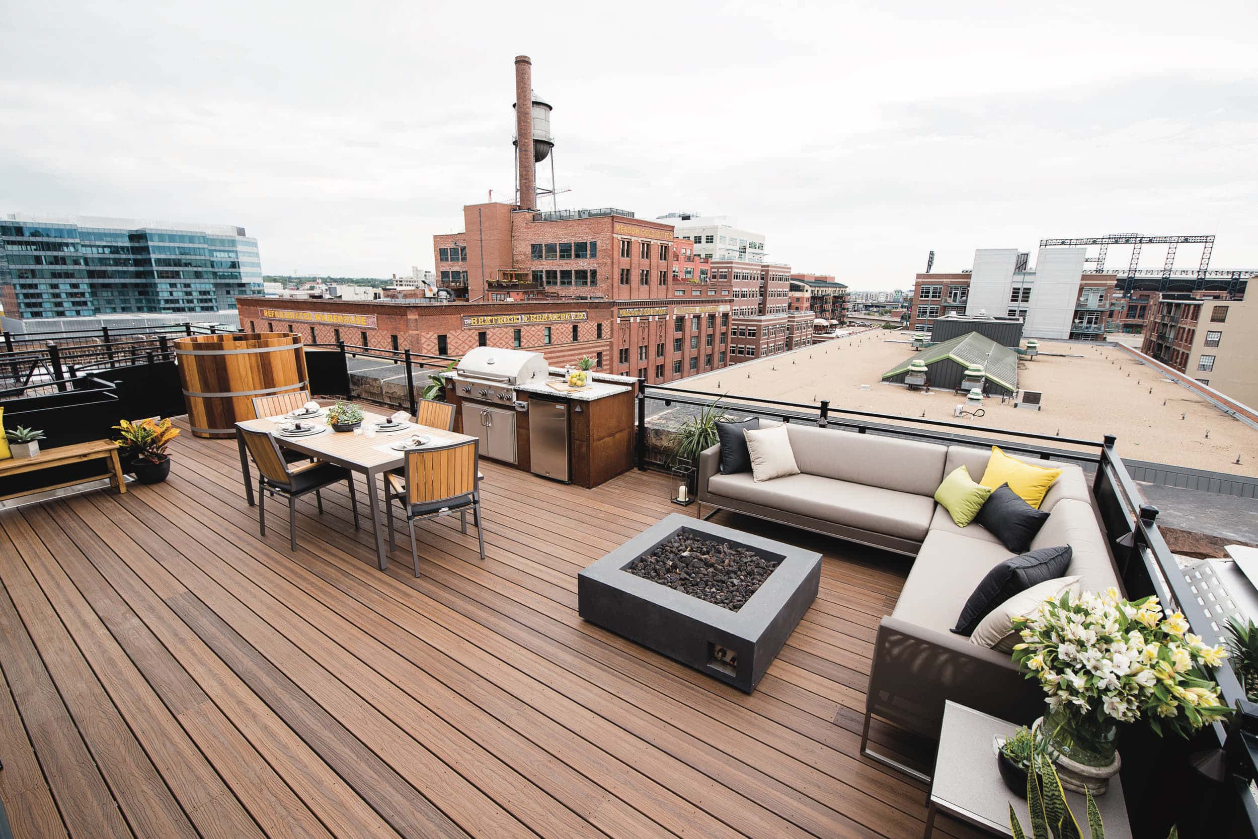 A rooftop deck with furniture and a fire pit.