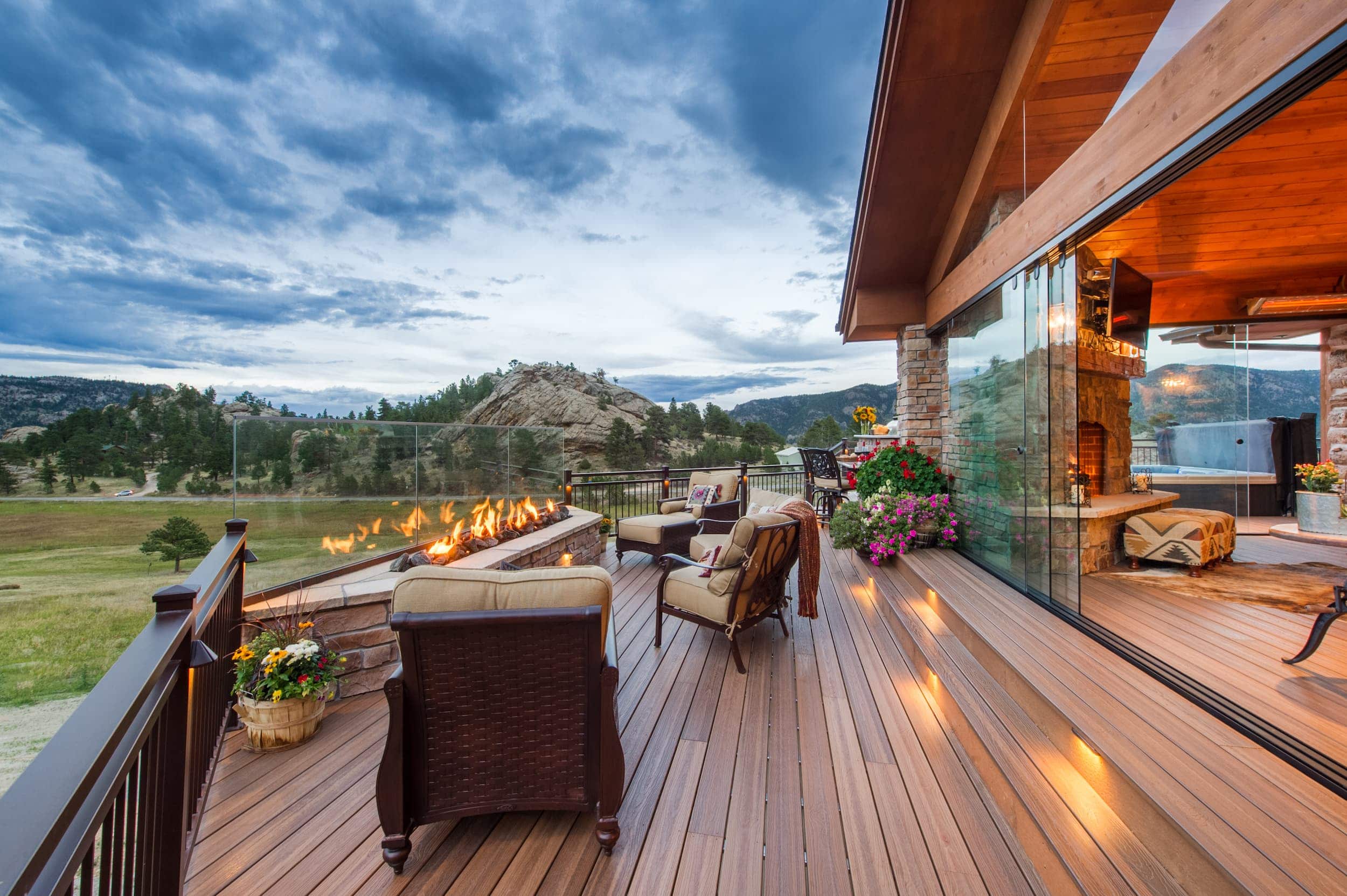 A deck with furniture and a view of the mountains.