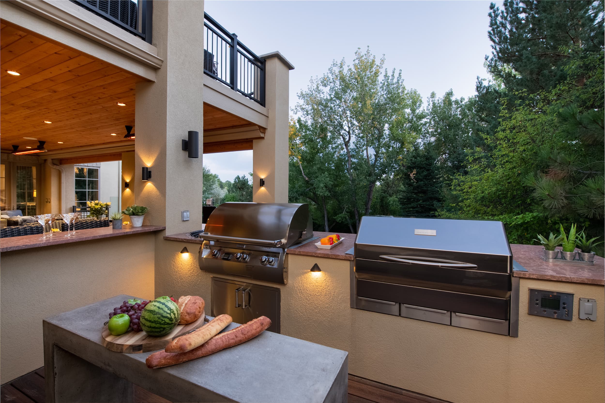 An outdoor kitchen with a grill and a table.