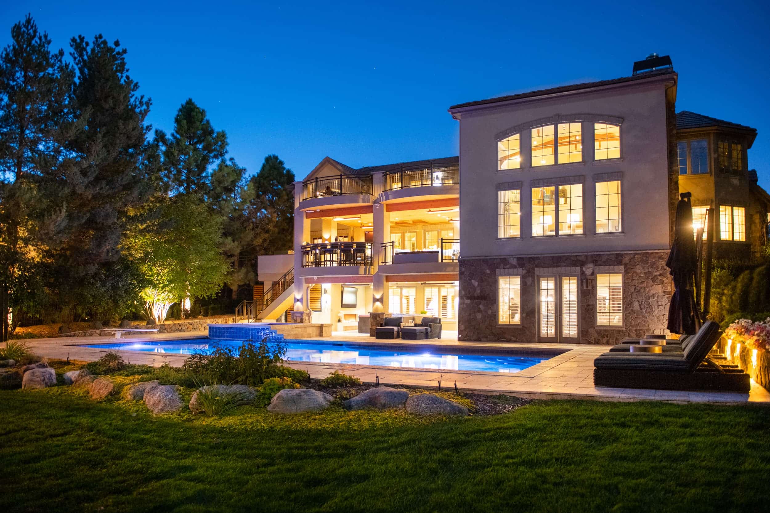 A large home with a pool at night.