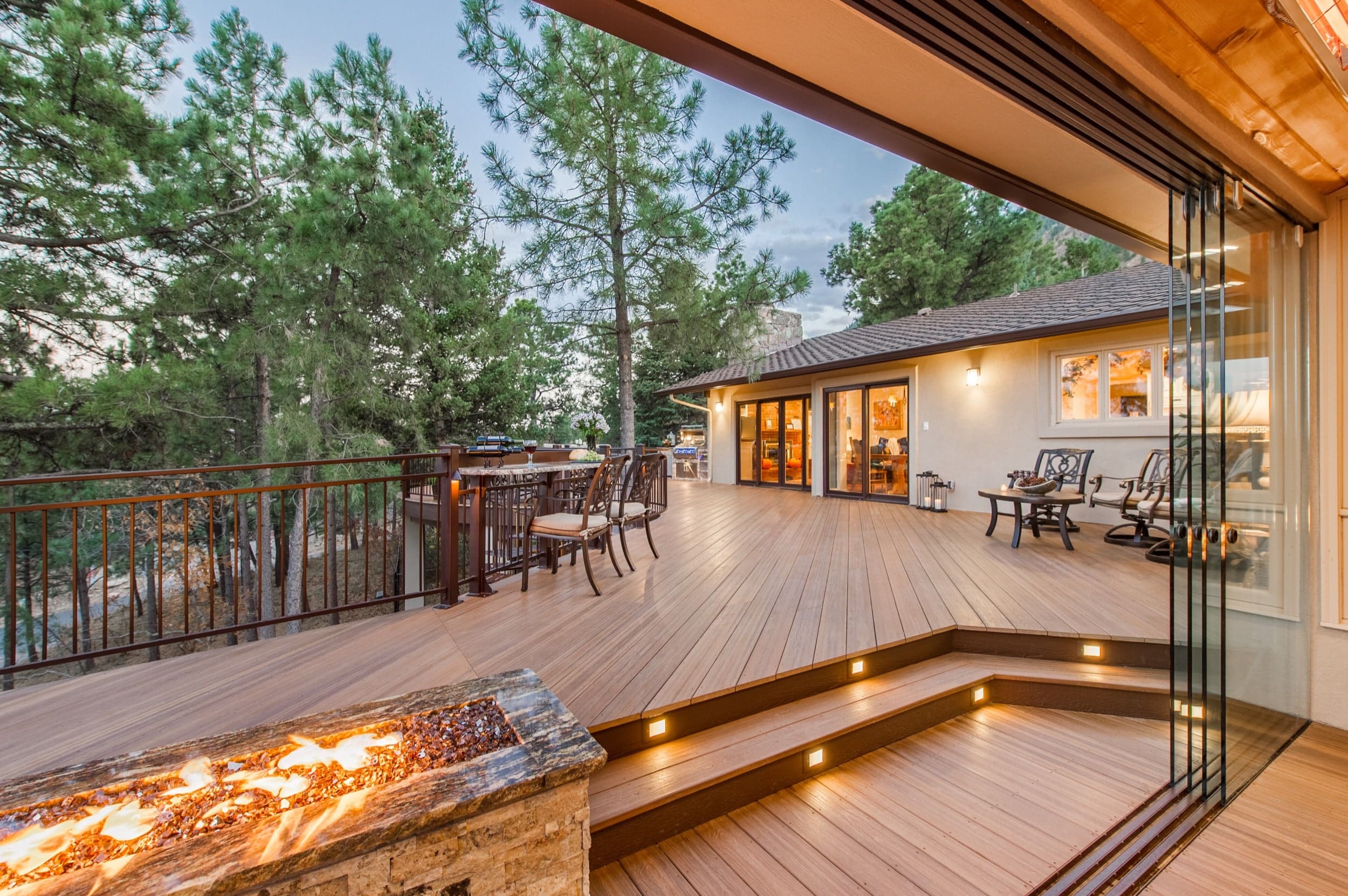 A deck with a fire pit and a view of the mountains.