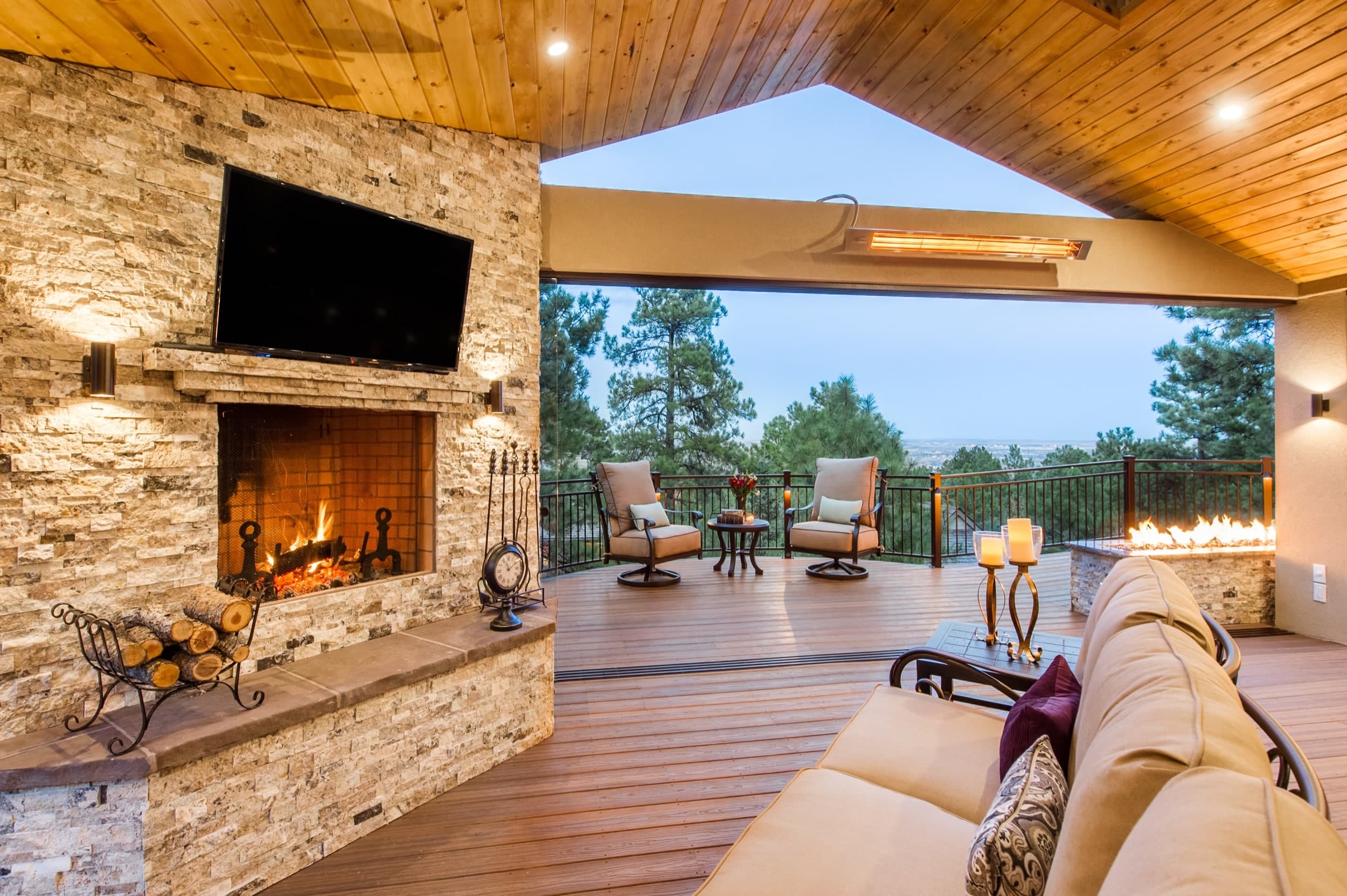 A deck with a fireplace and tv.