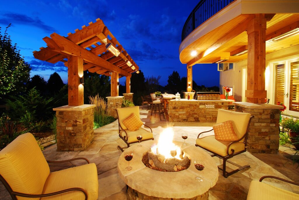 A firepit with chairs around it. There's also a pergola and an outdoor kitchen with grill.